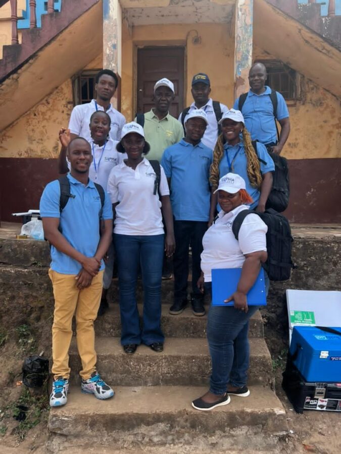 A group of people stand on a staircase outside